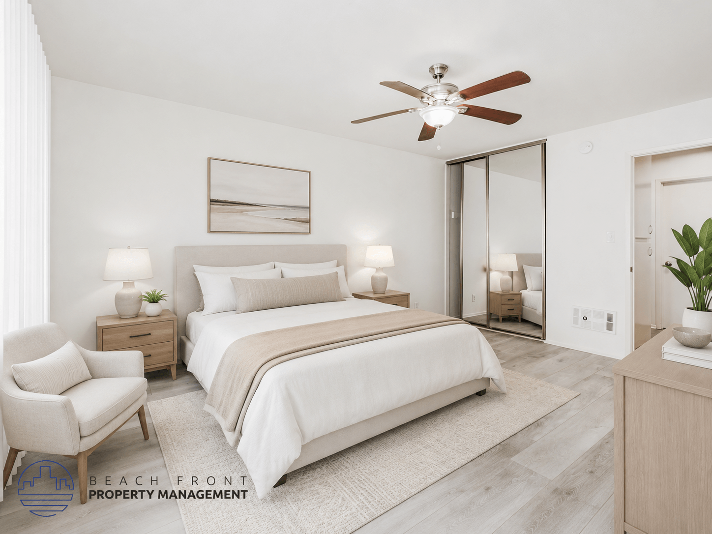 A well-lit bedroom with a large bed, a chair, and a ceiling fan.